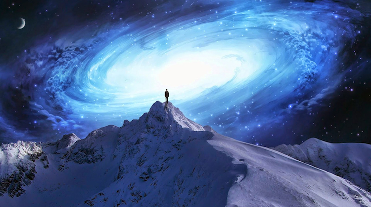 Man standing at the top of a mountain looking out at the universe to signify the mystery of consciousness and humanity's place in existence