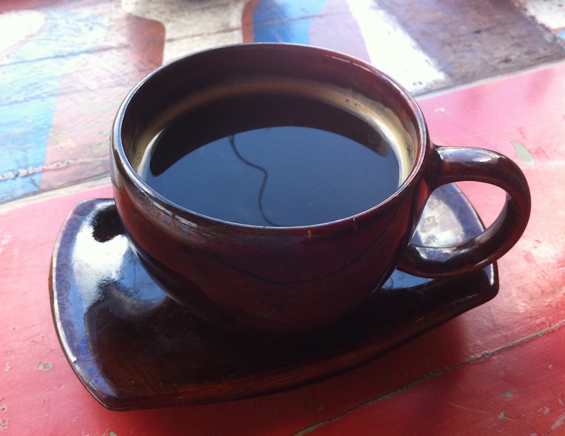 A black americano coffee in a brown cup with saucer