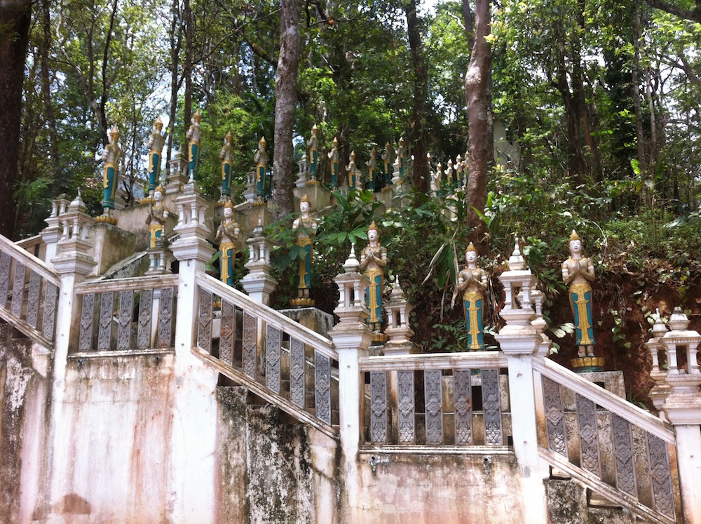 Stone staircase with statues lining the stairs at Doi Suthep Buddhist temple in Chiang Mai, Thailand